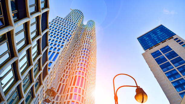 istock Bottom view of modern skyscraper in business district against blue sky. 1424816677