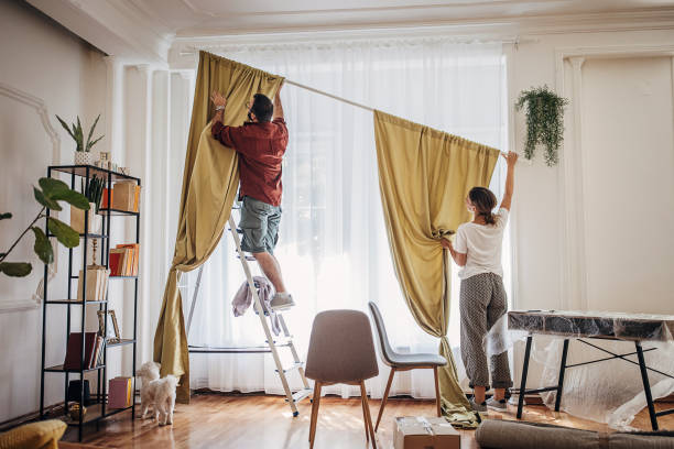 istock Couple installing window curtain together 1424818305
