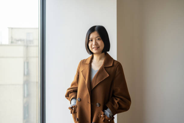 istock Asian woman looking at camera confidently by the window 1424821045