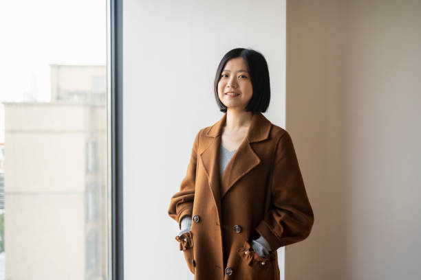 istock Asian woman looking at camera confidently by the window 1424821051