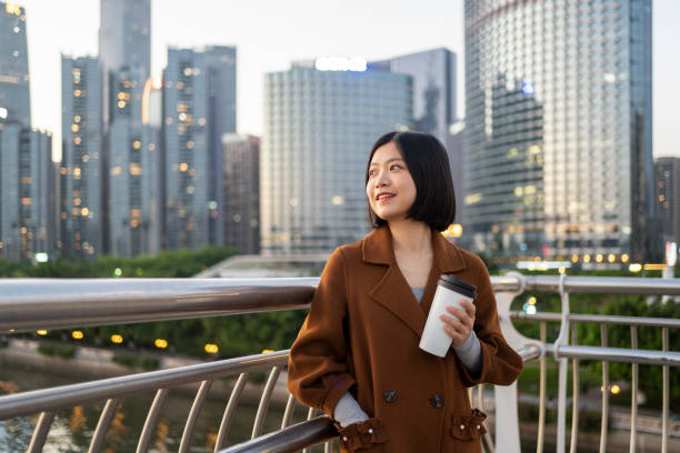 istock Asian woman looking into distance with coffee on commute 1424823809