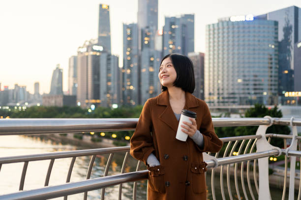 istock Asian woman looking into distance with coffee on commute 1424823918
