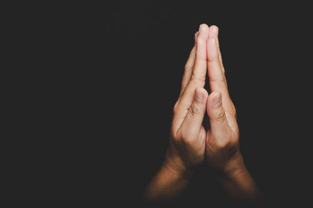 Close up Asian christian woman hands person pray and worship for thank god in church with black background, The concept for faith, spirituality and religion stock photo