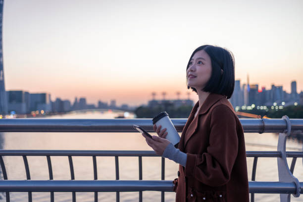 istock Asian woman using mobile phone on commute 1424824643