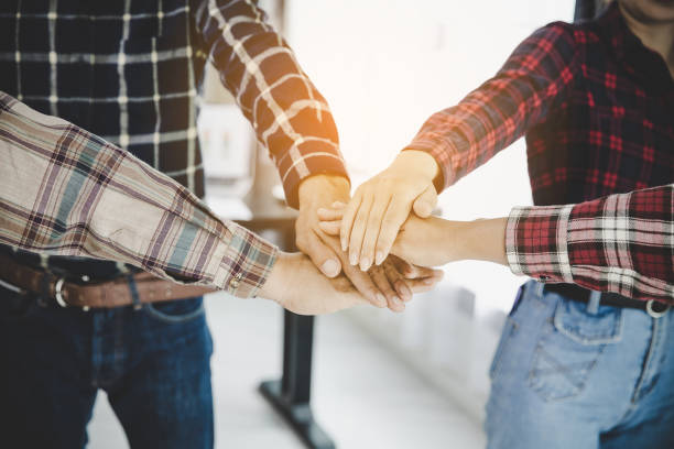 istock young business people putting their hands together 1424830389
