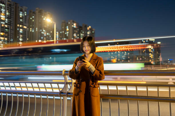 istock Asian woman using mobile phone on commute 1424830847
