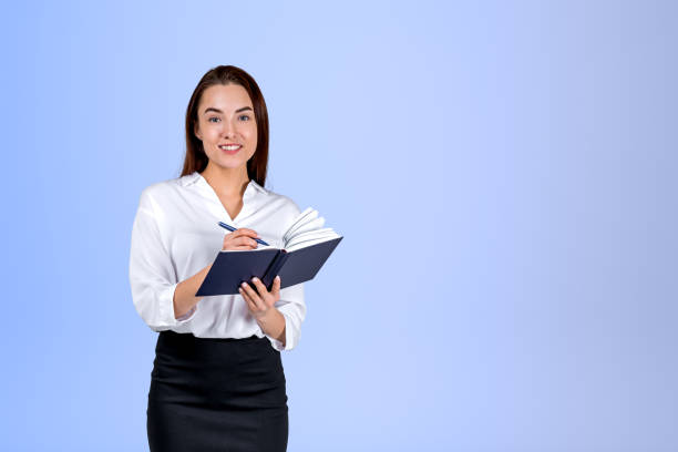 istock Businesswoman take note in notebook on light background. Copy space 1424833587