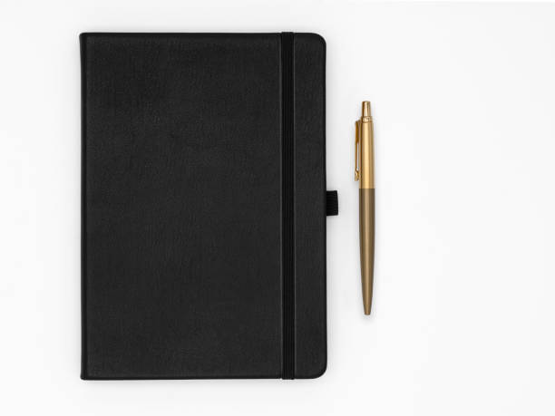 istock Quality black leather notebook with golden pen next to it, isolated on white background 1424835205
