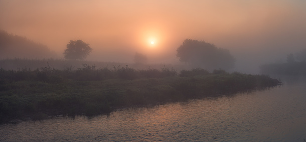 Majestic misty sunrise above the Teterev river. Ukrainian Woodland.