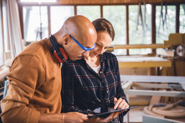 istock Couple of young carpenter working together 1424841592
