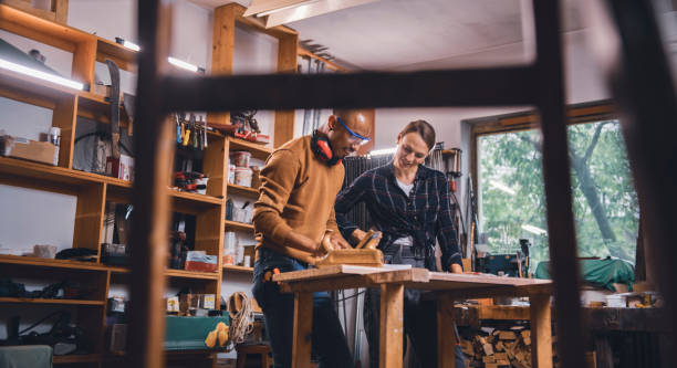 istock Couple of young carpenter working together 1424841602