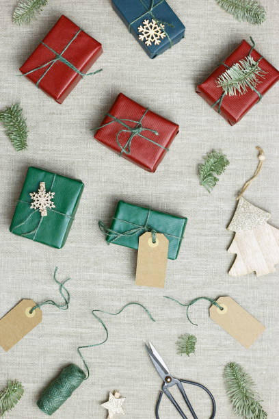 istock Christmas and New Year gift boxes, zero waste, eco friendly packaged gifts in kraft colored paper, green fir tree branches on table, preparation colorful xmas presents, eco christmas concept 1424845387