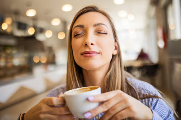 istock Stylish young woman drinking coffee at the cafe 1424846047