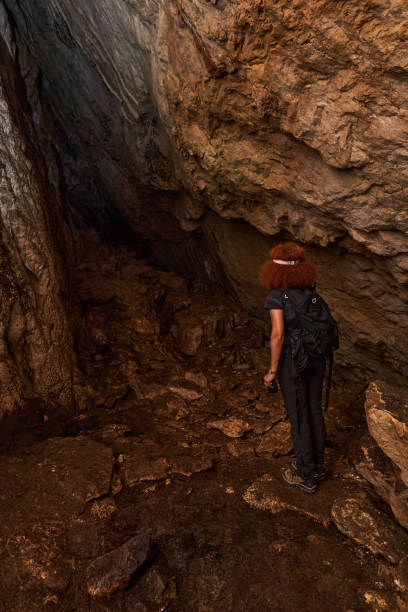istock Woman explorer in a cave 1424846381
