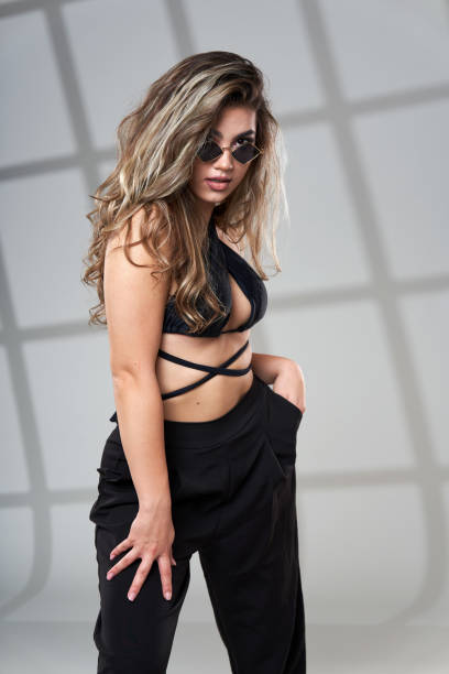 istock Trendy young woman in black on gray background 1424847687