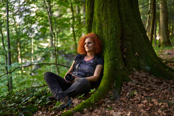 istock Nature photographer with camera in the forest mountain 1424849156