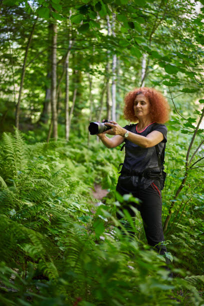 istock Nature photographer with camera in the forest mountain 1424849171