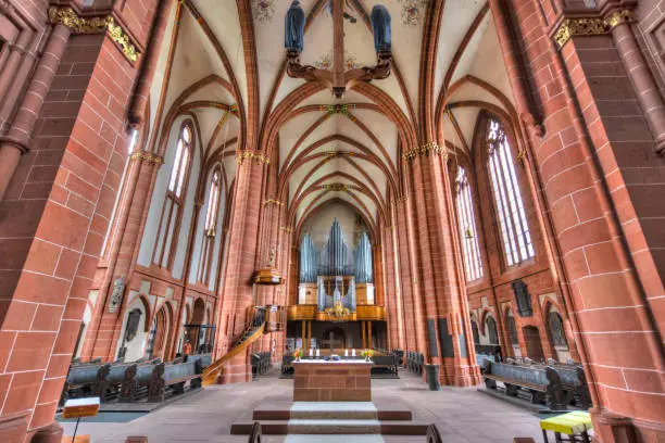 Empty interior of the Wetzlar Cathedral with church ceiling, pews, organ, the pulpit for the pastor and columns made of sandstone