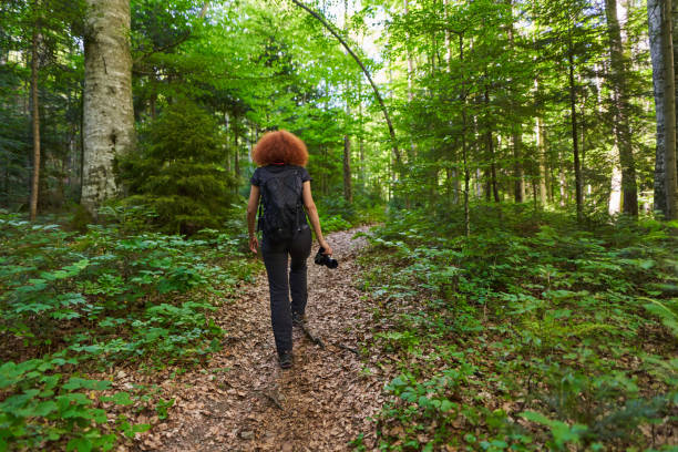istock Lady nature photographer hiking on a trail 1424849762