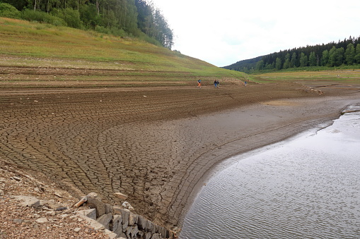 dried up empty reservoir and dam during a summer heatwave, low rainfall and drought in Saxony, Germany, Talsperre Lehnmuehle