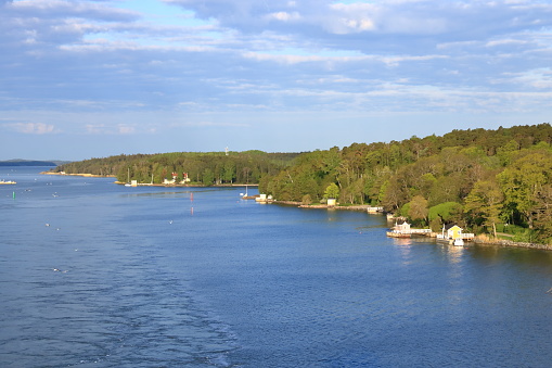 the Beautiful scenery of natural environment of Turku archipelago surrounded with the greenery of pine trees and water surface with tall water grass and local sailing boats
