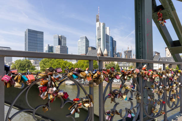 Love locks on the Iron footbridge over the Main river in Frankfurt, Germany with the skyline of Frankfurt in the background