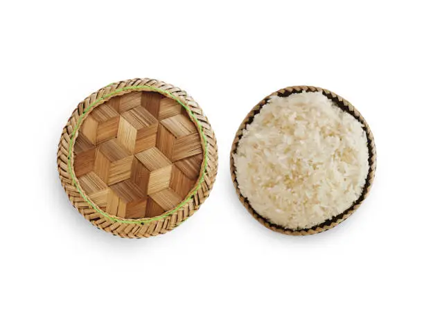 Traditional patterned bamboo box with Thai sticky rice on white background.
