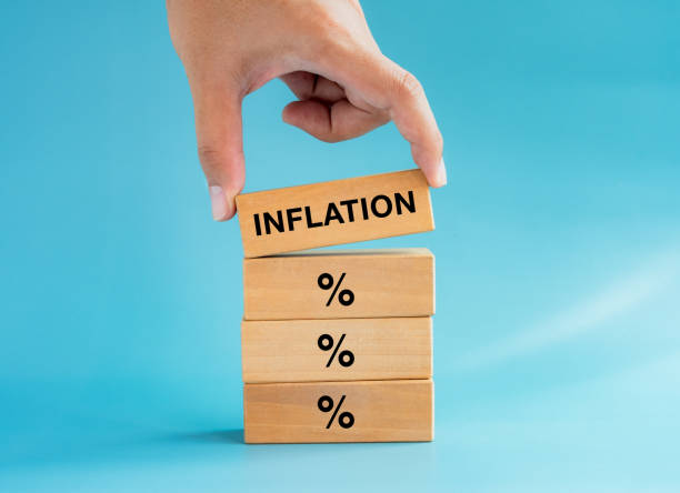 istock Close-up hand put the words, INFLATION on percentage icon sign on wooden cube blocks stack isolated on blue background. Inflation and financial crisis business concepts. 1424866788