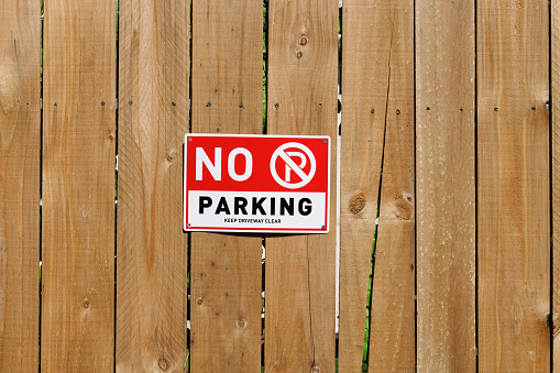 No Parking sign on an old wooden fence.