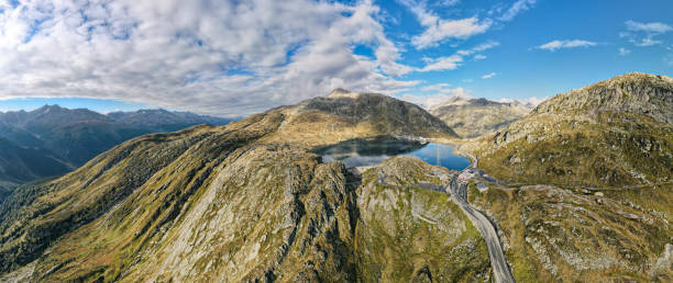 aerial view overlooking the Grimsel Pass summit in the swiss alps View of the top of the pass, the Totensee reservoir, the road and the partly cloudy sky. The famous swiss mountain pass roads Grimselpass, near the Furkapass, canton of Valais on the border with canton of Bern, switzerland grimsel pass photos stock pictures, royalty-free photos & images