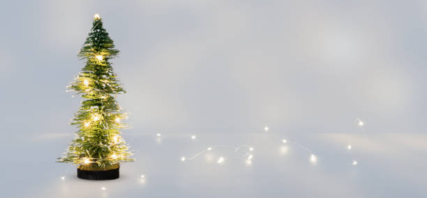 istock bright christmas tree decoration in an abstract icy room with copy space, shiny string lights on white background concept for december holiday season 1424868752