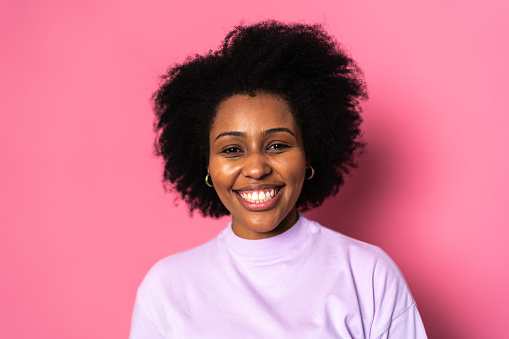 Portrait of a young woman on pink background