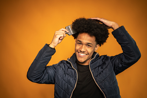 Portrait of a young man combing his hair