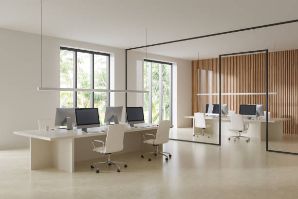 Office interior with coworking zone and pc computers, panoramic window stock photo