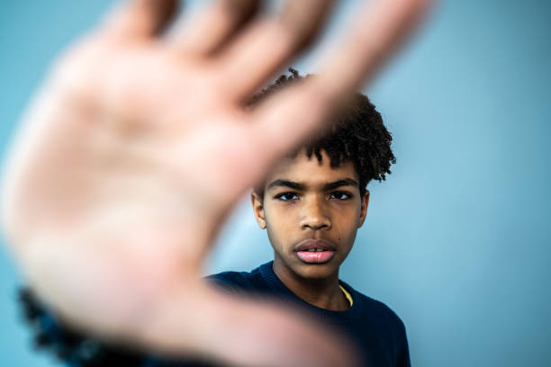 portret chłopca robiącego przestań gestykulować na niebieskim tle - stop gesture zdjęcia i obrazy z banku zdjęć