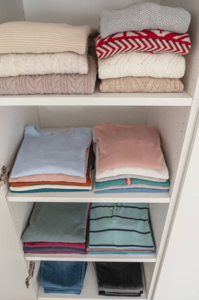 istock Pastel clothes folded on shelves in wardrobe 1424874492