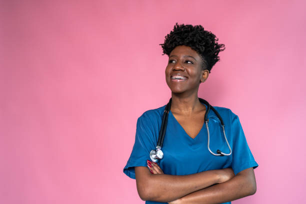 istock Young nurse / doctor on a pink background 1424877498
