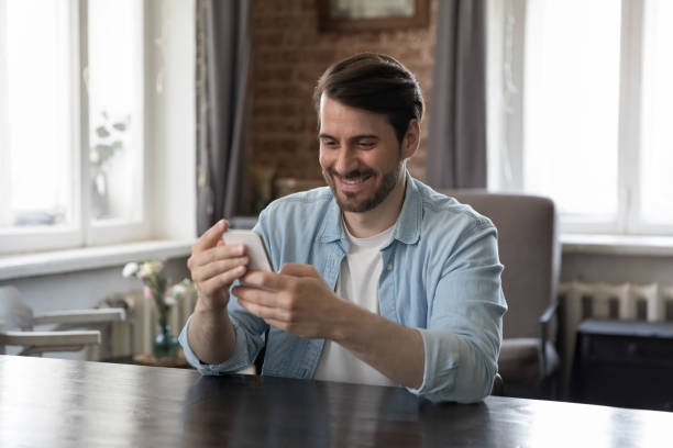 istock Cheerful millennial smartphone user man talking on video call 1424880444