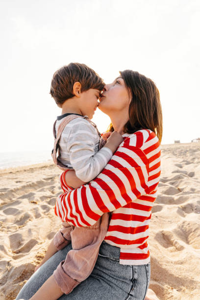 spędzenie jesiennego dnia na plaży - single mother one parent child kissing zdjęcia i obrazy z banku zdjęć