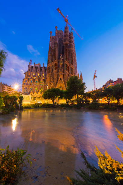 Sagrada Familia at twilight, in the blue hour, reflected in the water on a summer night.