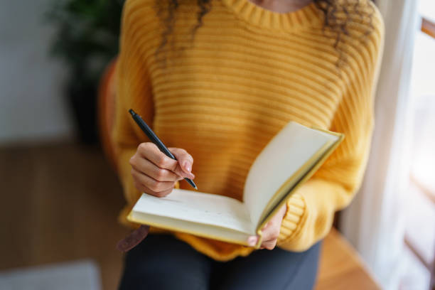 istock woman holding a pen to write down memories 1424890561