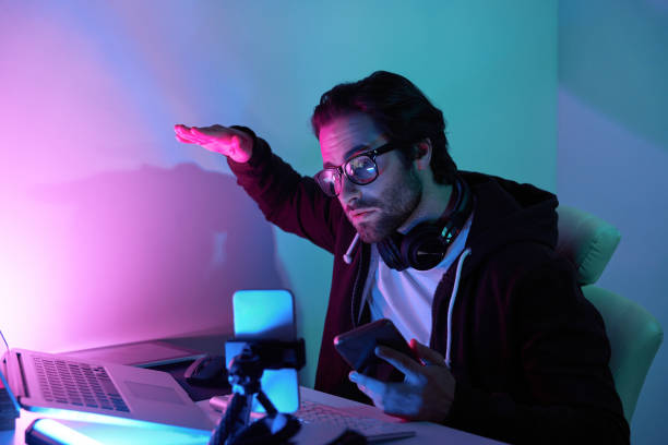 istock Concentrated young man using computer and streaming online against colorful background 1424899522