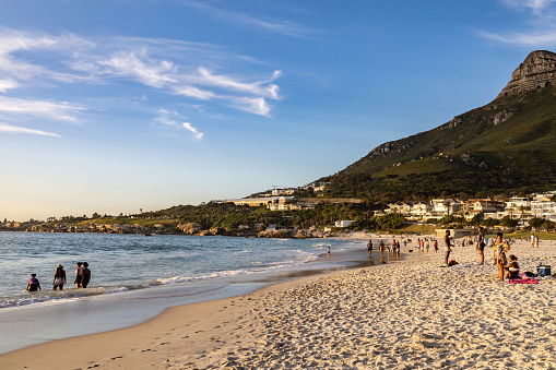 Cape Town, South Africa - September 14, 2022:  People of different races enjoy the beach at Camps Bay in Cape Town, South Africa.