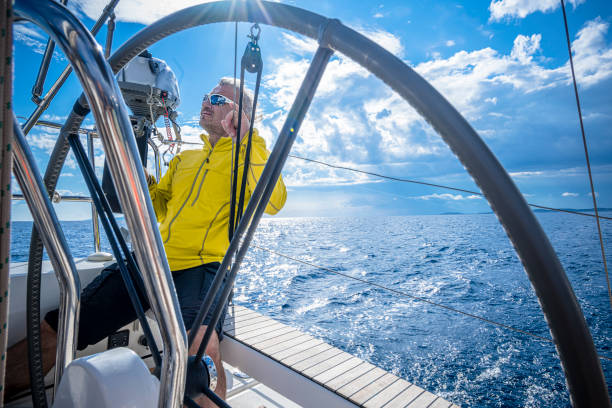 the man drives a sailboat on an autopilot and enjoys it. - yacht nautical vessel autopilot sailing imagens e fotografias de stock