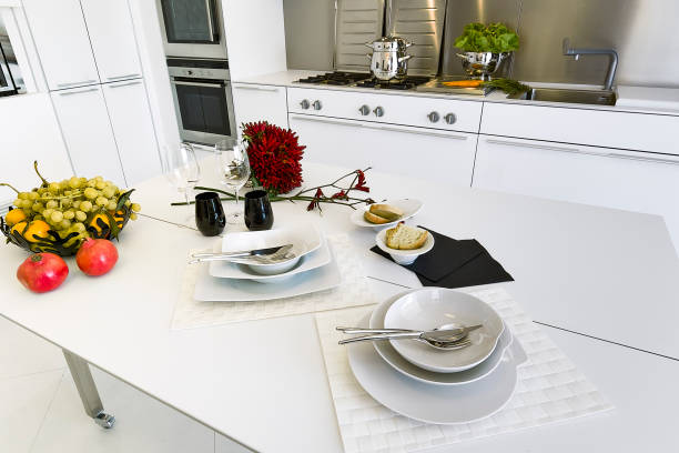 close-up of fresh fruits and red peppers with white dishes on the dining table in the modern white  kitchen