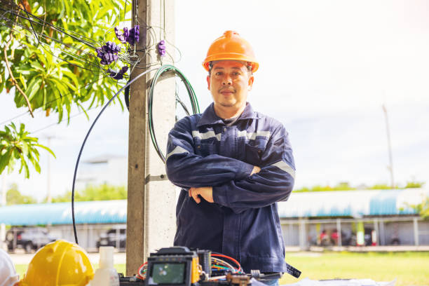 istock Outside, an ISP Internet Service Provider engineer stands near a fiber optic cross box. 1424906815