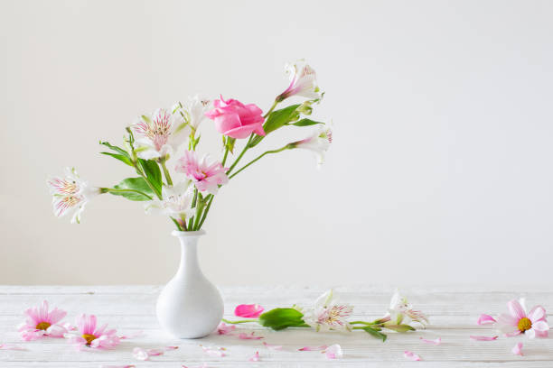 istock pink and white flowers in vase on white background 1424907314