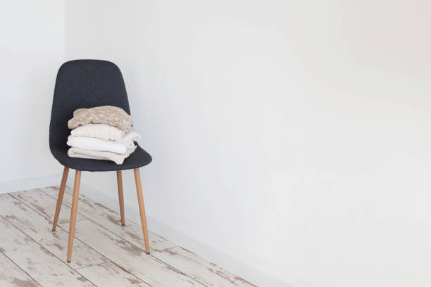 istock stack of sweaters on  gray modern chair in  white room 1424907395