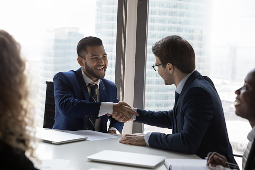 Company leader, boss congratulating happy successful employee on career growth, success, shaking hand with recognition, reward. Business partners giving handshakes, ending meeting, closing deal