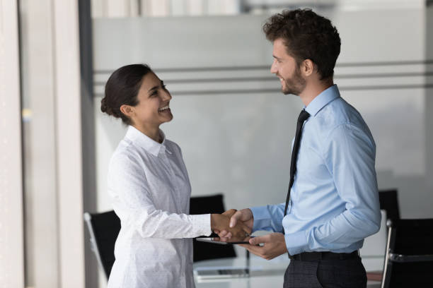 istock Two happy confident diverse business people shaking hands in office 1424912378